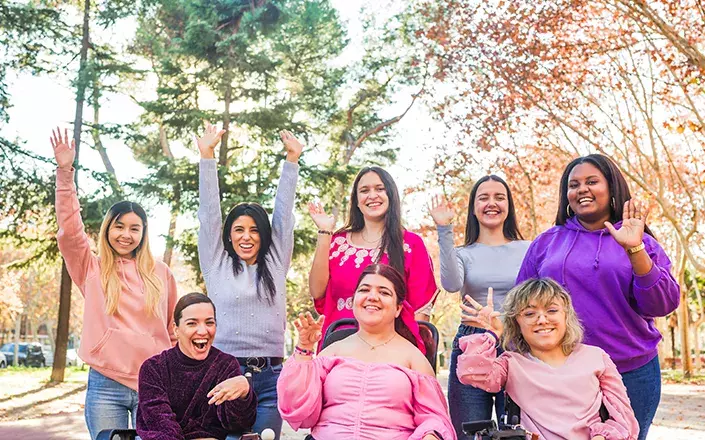 Un groupe de femmes en situation de handicap qui posent pour une photo. Elles ont beaucoup d'énergie et font des gestes de joie.